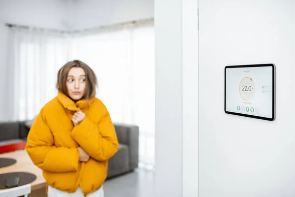 Smart home digital panel with heating app and woman feeling cold — Stockfoto
