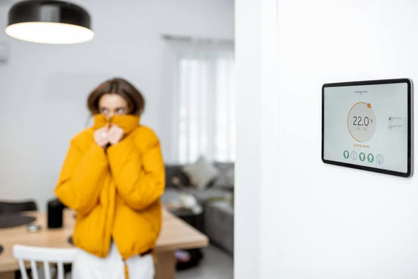 Smart home digital panel with heating app and woman feeling cold — Stockfoto