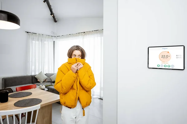 Woman feeling cold, controlling heating with a smart devices at home — Stock fotografie