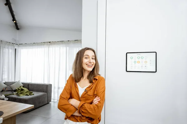 Retrato de una mujer feliz controlando el hogar con una tableta digital —  Fotos de Stock