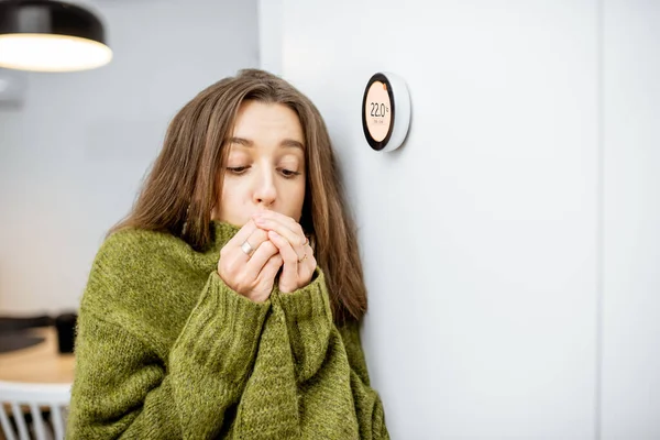 Жінка відчуває холодний контроль нагрівання з розумним пристроєм вдома — стокове фото