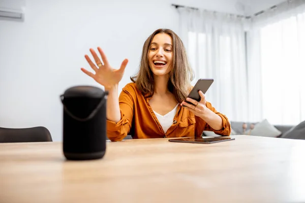 Woman controlling home devices with a voice commands — Stockfoto