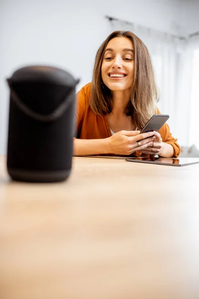 Mujer controlando dispositivos domésticos con comandos de voz — Foto de Stock