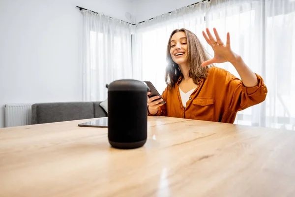 Woman controlling home devices with a voice commands — Stockfoto