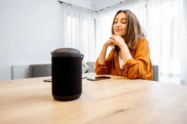 Woman with a smart wireless speaker at home — Φωτογραφία Αρχείου