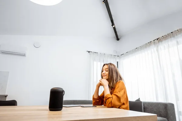 Woman with a smart wireless speaker at home