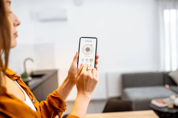 Woman controlling ventilation with a smart phone at home — Φωτογραφία Αρχείου