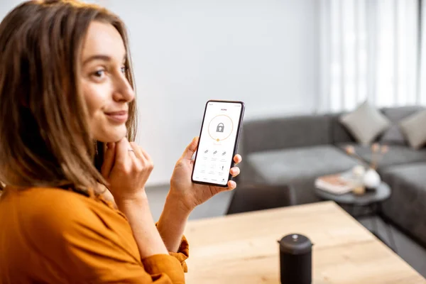 Woman controlling security from a mobile device — Φωτογραφία Αρχείου