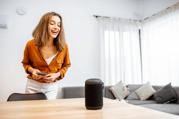 Woman controlling home devices with a voice commands