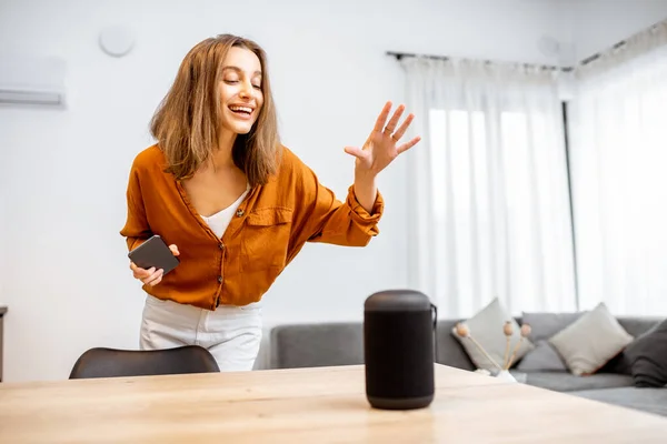 Woman controlling home devices with a voice commands