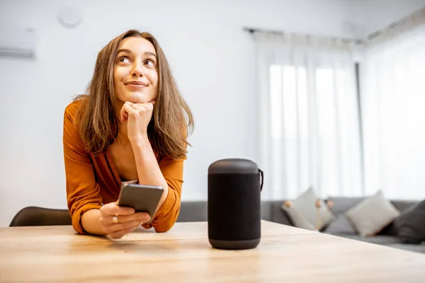 Woman with smart wireless column at home — Stockfoto