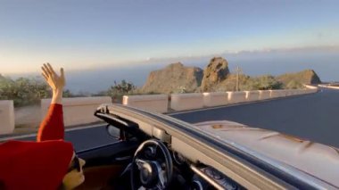 Woman driving a cabriolet while travel
