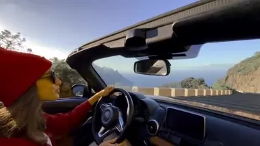 Woman driving a cabriolet while travel
