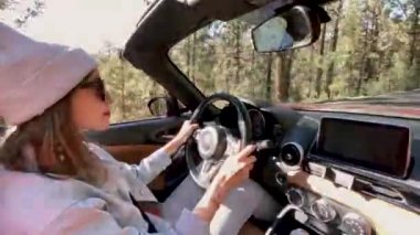 Woman driving a cabriolet while travel