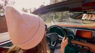 Woman driving a cabriolet while travel