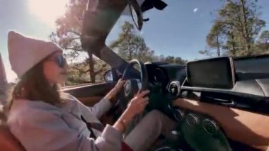 Woman driving a cabriolet while travel