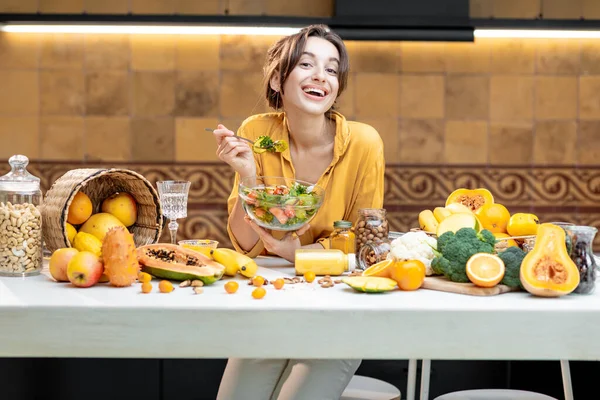 Jovem com alimentos frescos saudáveis na cozinha — Fotografia de Stock