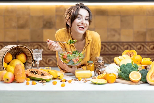 Jovem com alimentos frescos saudáveis na cozinha — Fotografia de Stock