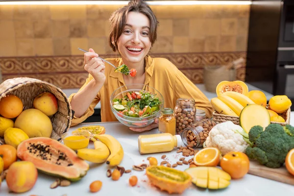 Mujer joven con alimentos frescos saludables en la cocina — Foto de Stock