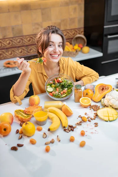 Mujer joven con alimentos frescos saludables en la cocina — Foto de Stock