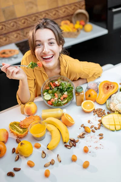 Mujer joven con alimentos frescos saludables en la cocina — Foto de Stock