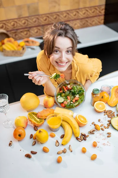 Mujer joven con alimentos frescos saludables en la cocina — Foto de Stock