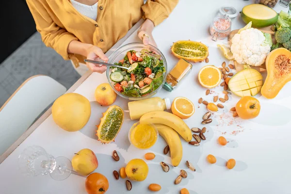 Jovem com alimentos frescos saudáveis na cozinha — Fotografia de Stock
