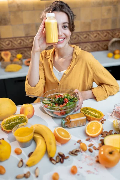 Jeune femme avec de la nourriture fraîche saine sur la cuisine — Photo