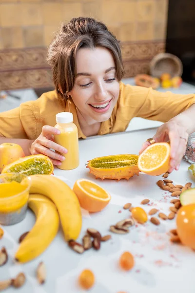 Mujer joven con alimentos frescos saludables en la cocina —  Fotos de Stock