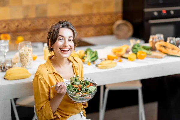 Ung kvinna med hälsosam färsk mat på köket — Stockfoto