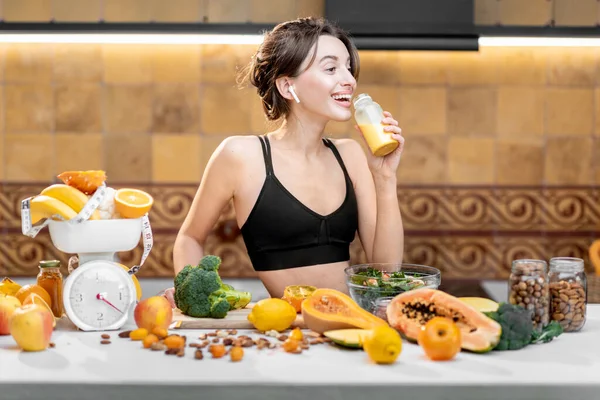 Femme sportive avec des aliments sains sur la cuisine — Photo