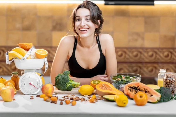 Mulher de esportes com comida saudável na cozinha — Fotografia de Stock