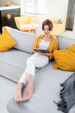 Dijital tabletli kadın evde dinleniyor