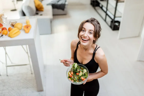 Sport kvinna med hälsosam mat hemma — Stockfoto