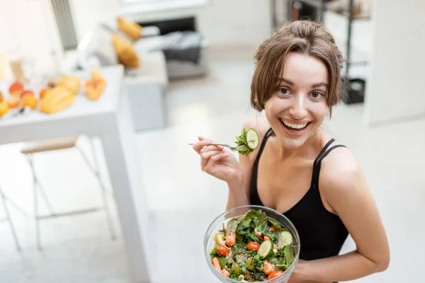 Mujer deportiva con comida saludable en casa — Foto de Stock