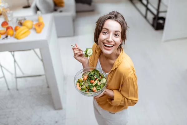 Vrouw die thuis salade eet — Stockfoto