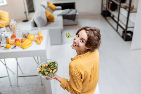 Kvinna äter sallad hemma — Stockfoto