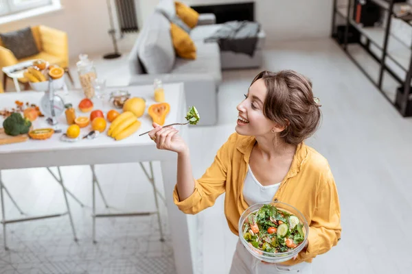 Kvinna äter sallad hemma — Stockfoto