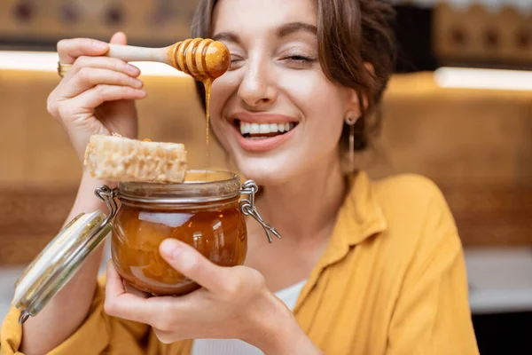 Femme mangeant du miel à la maison — Photo