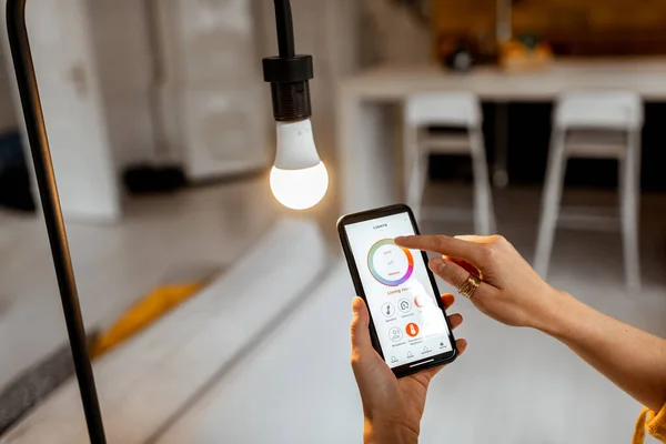 Controlling light bulb with mobile device — Stockfoto