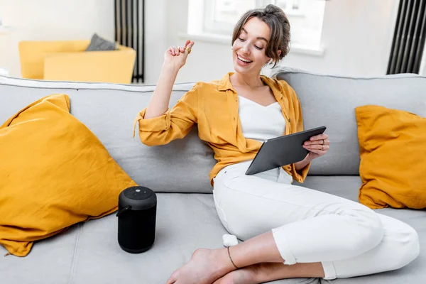 Woman controlling smart home devices with a voice commands — Stok fotoğraf