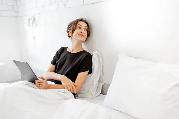 Frau mit Tablette im Bett — Stockfoto