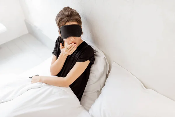 Woman in sleeping mask in bed — Stockfoto