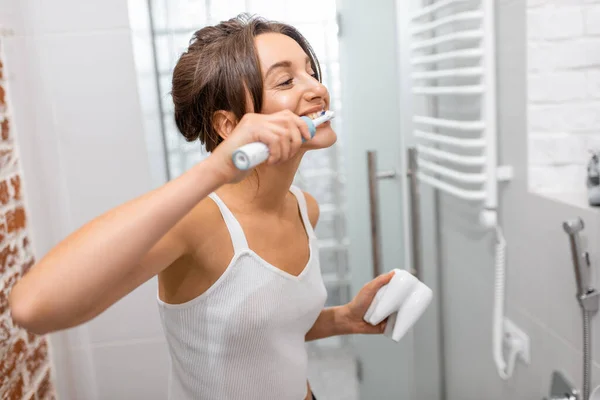 Žena čištění zubů s elektrickým zubním kartáčkem — Stock fotografie