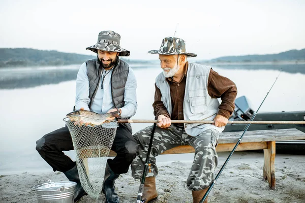 Grand-père avec fils pêche sur le lac — Photo
