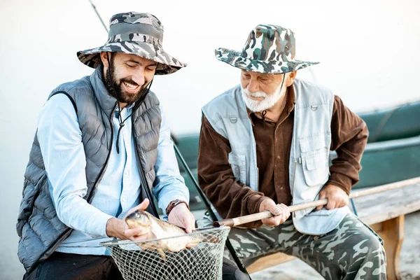 Grandfather with son fishing on the lake — Stockfoto