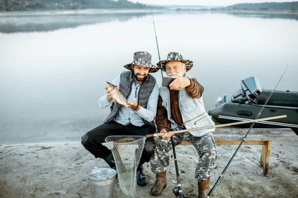 Дідусь з сином рибалка на озері — стокове фото