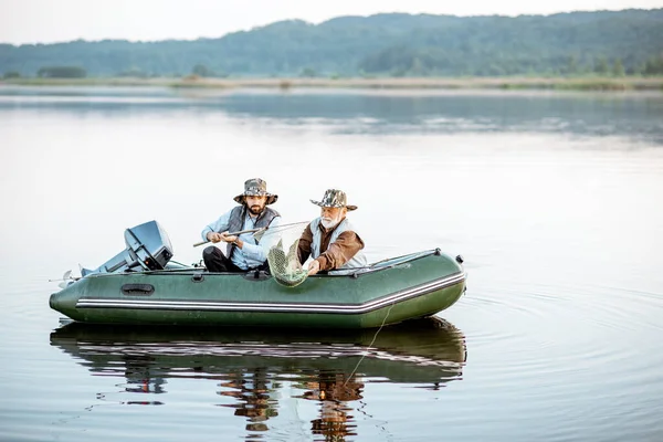 Avô com filho pescando no barco — Fotografia de Stock