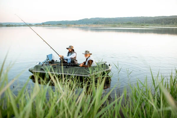 Grand-père avec son fils pêche sur le bateau — Photo