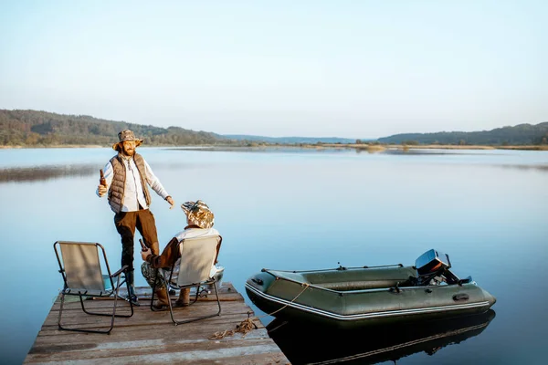 Grandfather with adult son talking on fishing — 图库照片